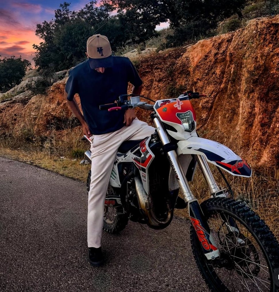 Hamzah Tarawneh on a white and red dirt bike at sunset